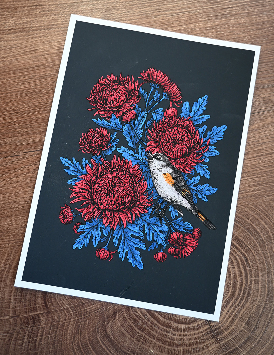 Printed illustration of red mum flowers and a bird on a black background