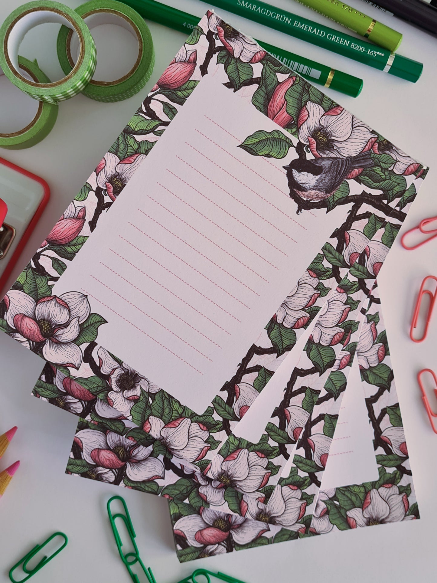 photo of a hand-made notepad illustrated with Magnolia and Chickadee birds