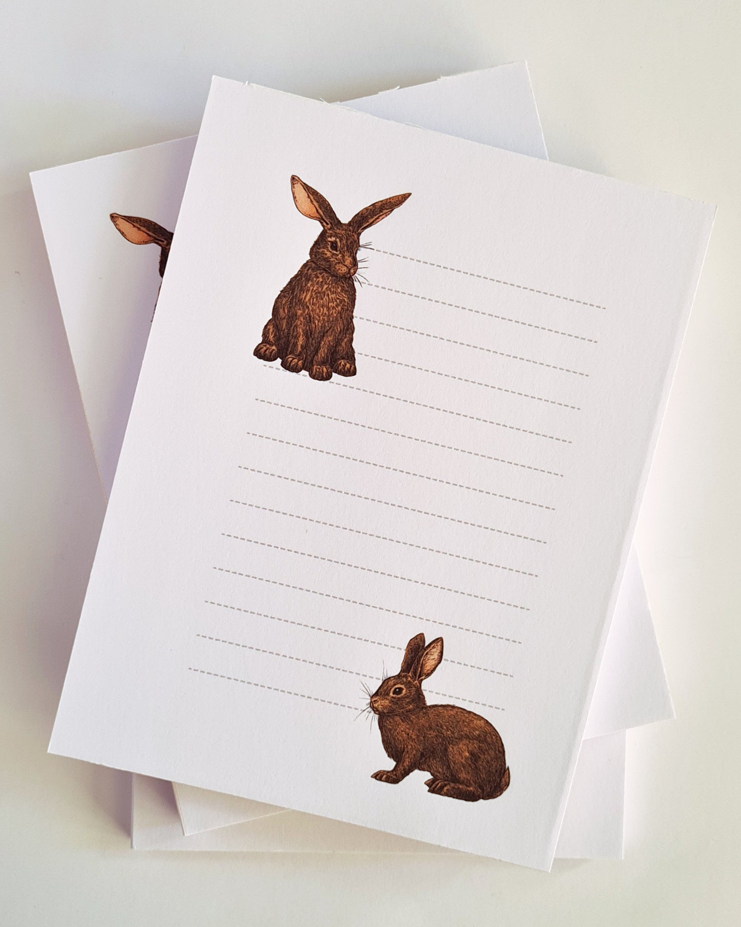 photo featuring a notepad illustrated with 2 rabbits and lined space for notes