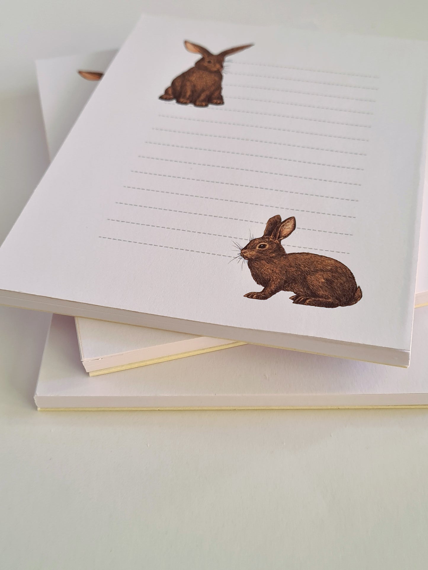 photo featuring a notepad illustrated with 2 rabbits and lined space for notes