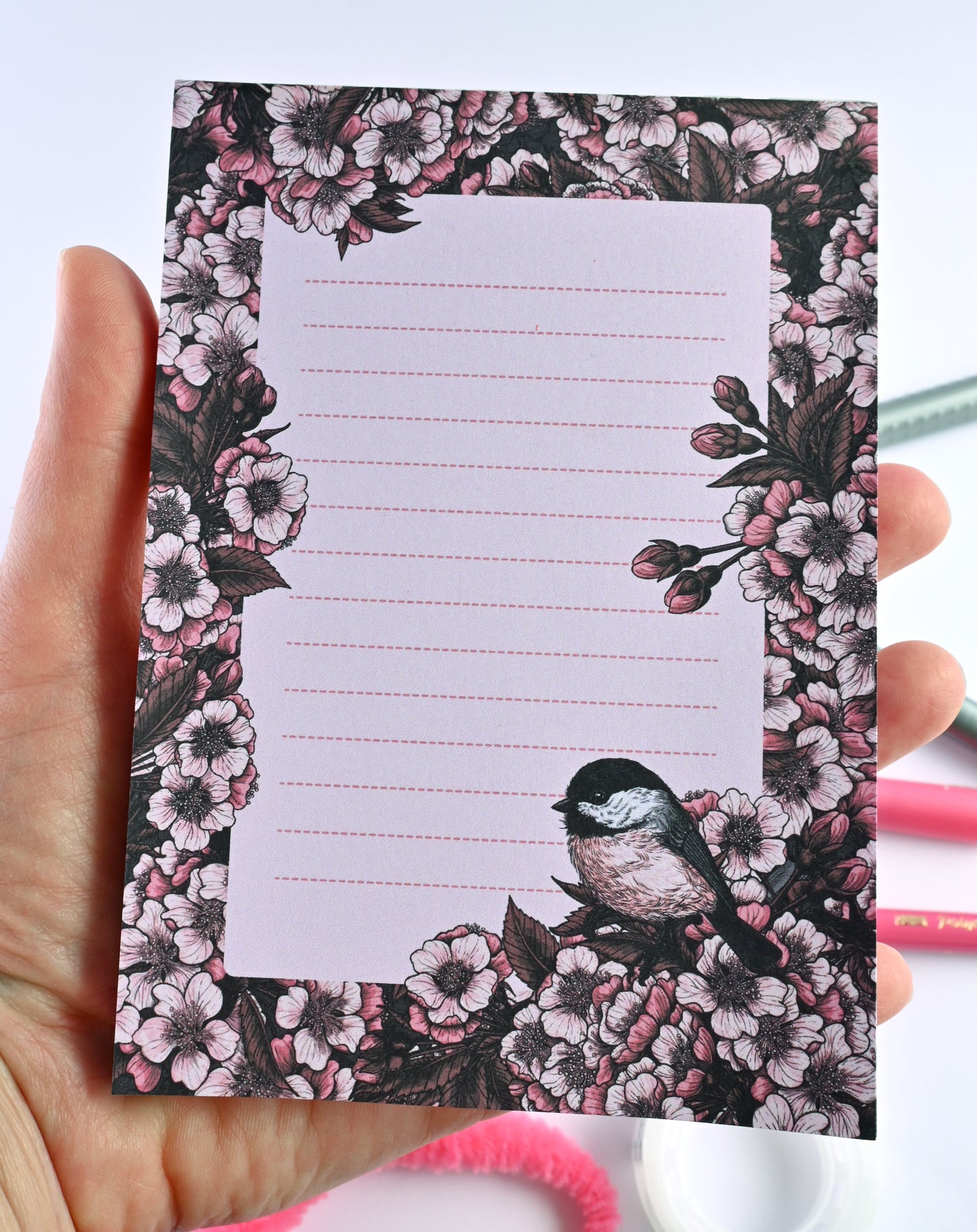 notepad featuring hand painted frame of cherry blosssom and chicakee bird in the lower right corner and lined middle