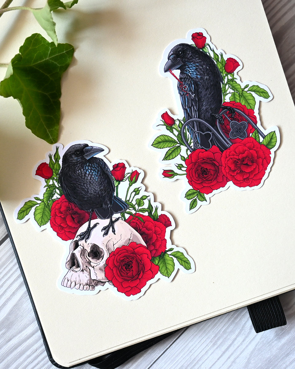photo of 2 vinyl stickers with printed illustrations of a ravens and red roses