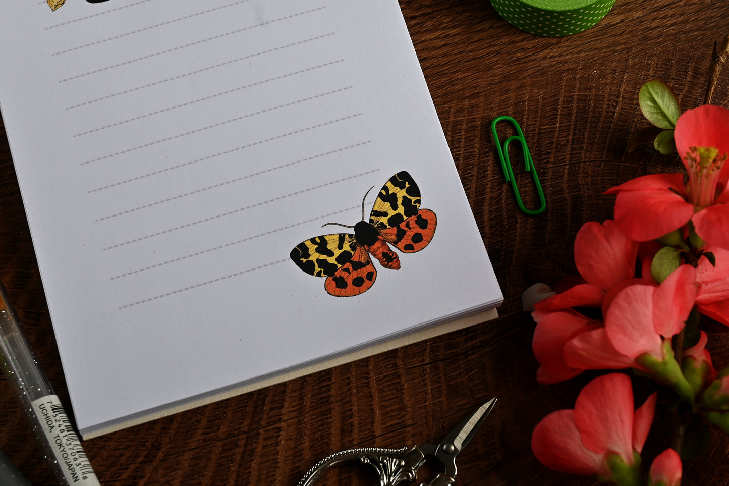 photo featuring a notepad illustrated with 2 moths