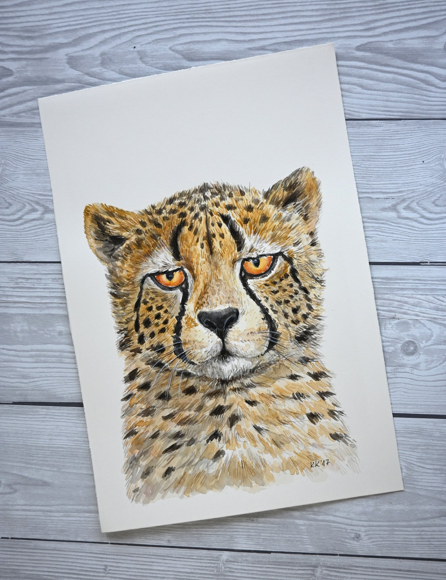 Watercolor painting of a cheetah's head on a textured paper background