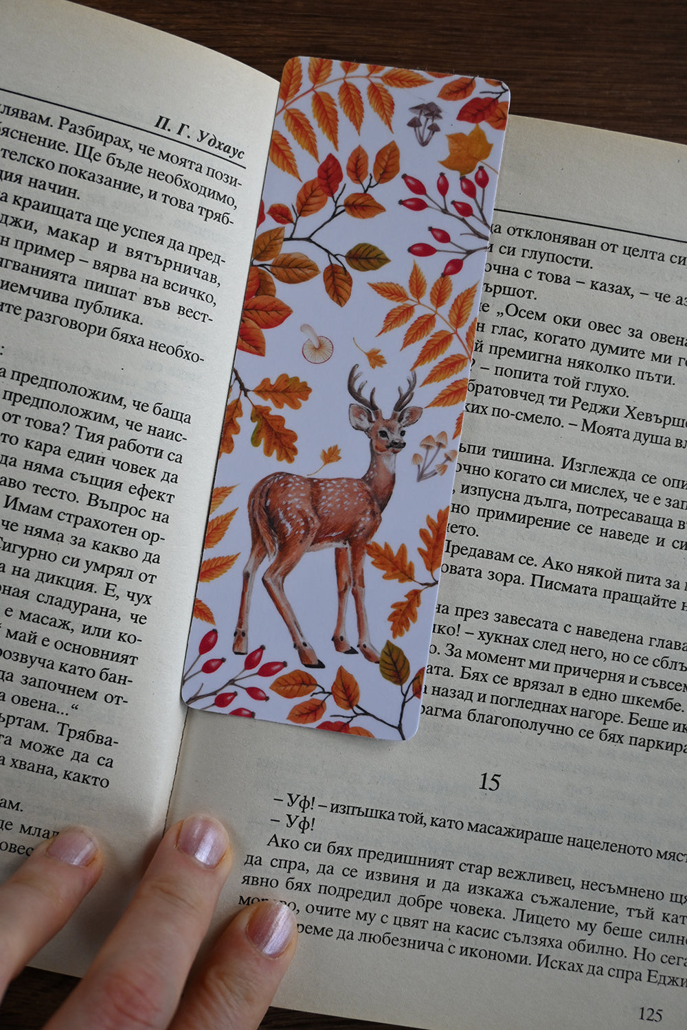 Book with a decorative bookmark featuring a deer and autumn leaves on an open book.