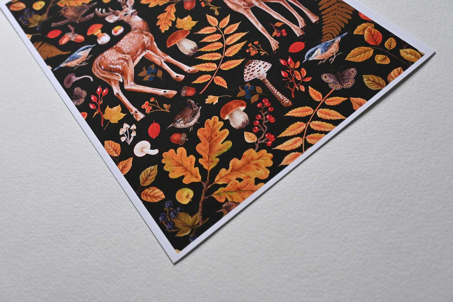 close up of the corner of print of two deer among autumnal flora, mushrooms and birds