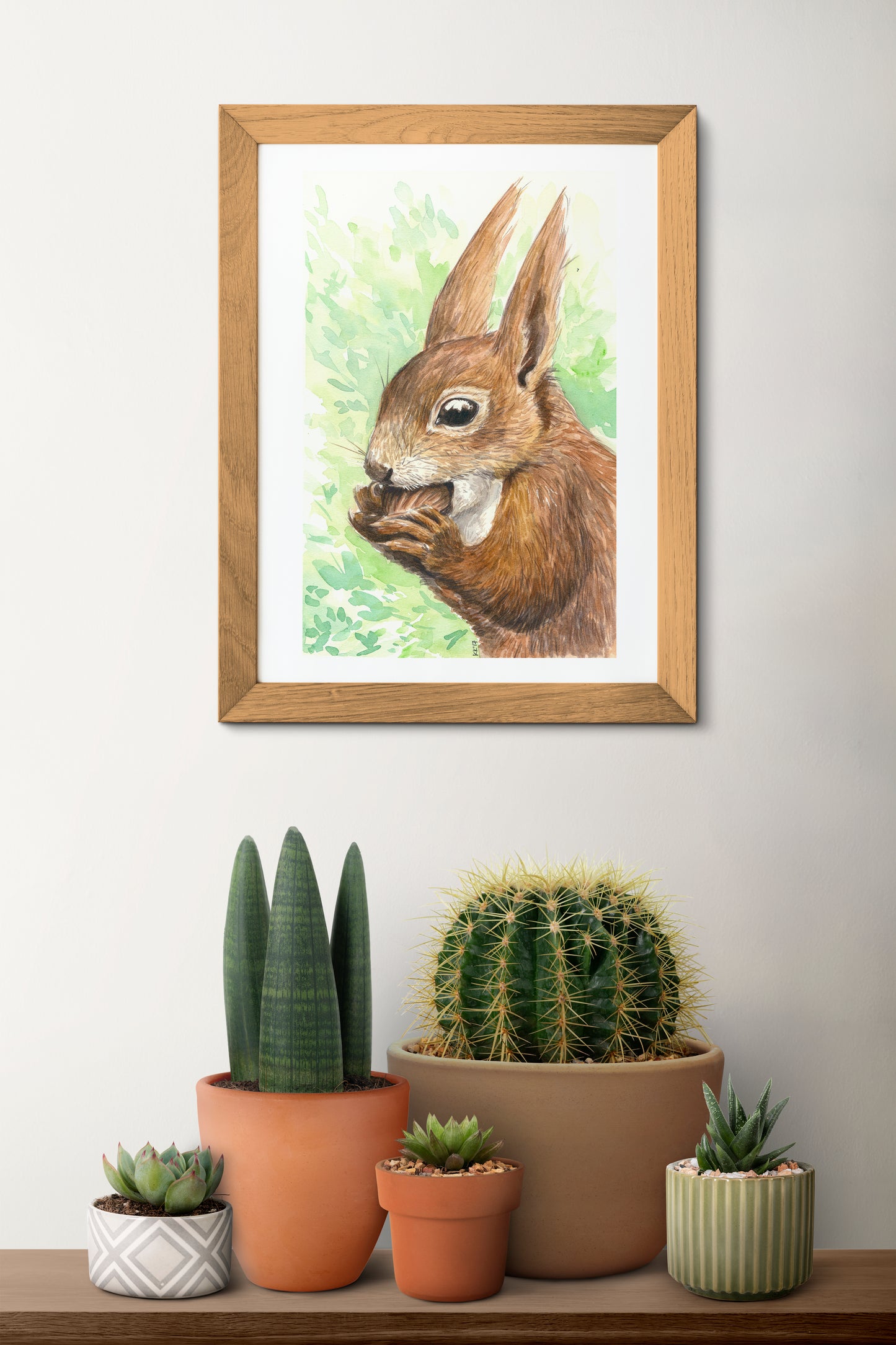 Framed artwork of a squirrel on a wall above a shelf with potted plants.