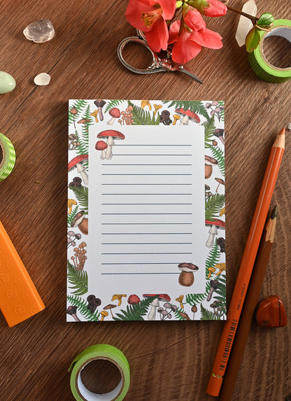 photo featuring a notepad illustrated with wild mushrooms and fern