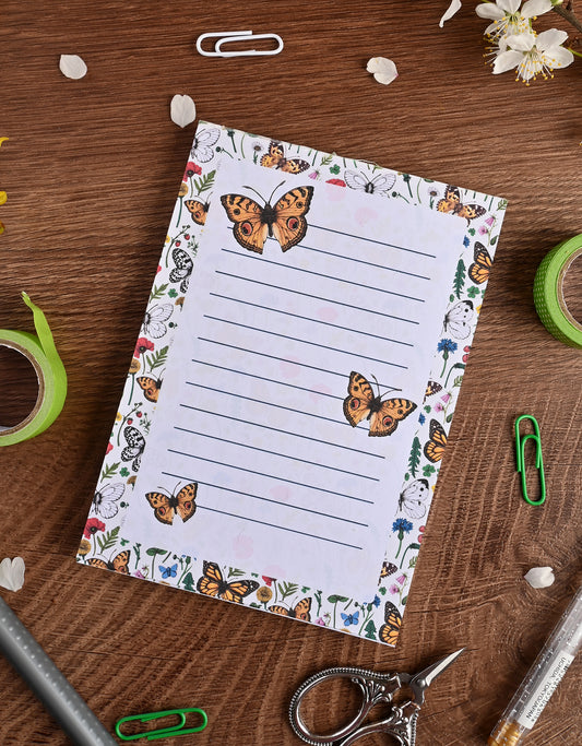 photo featuring a notepad illustrated with wildflowers and butterflies