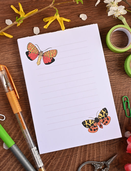 photo featuring a notepad illustrated with 2 moths