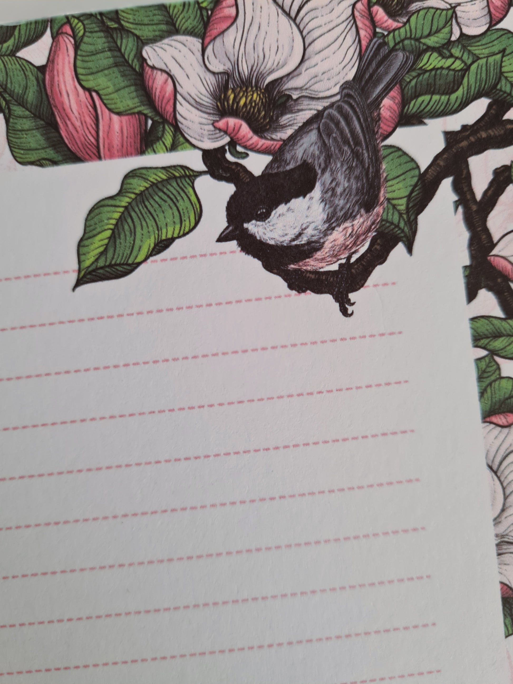 photo of a hand-made notepad illustrated with Magnolia and Chickadee birds 