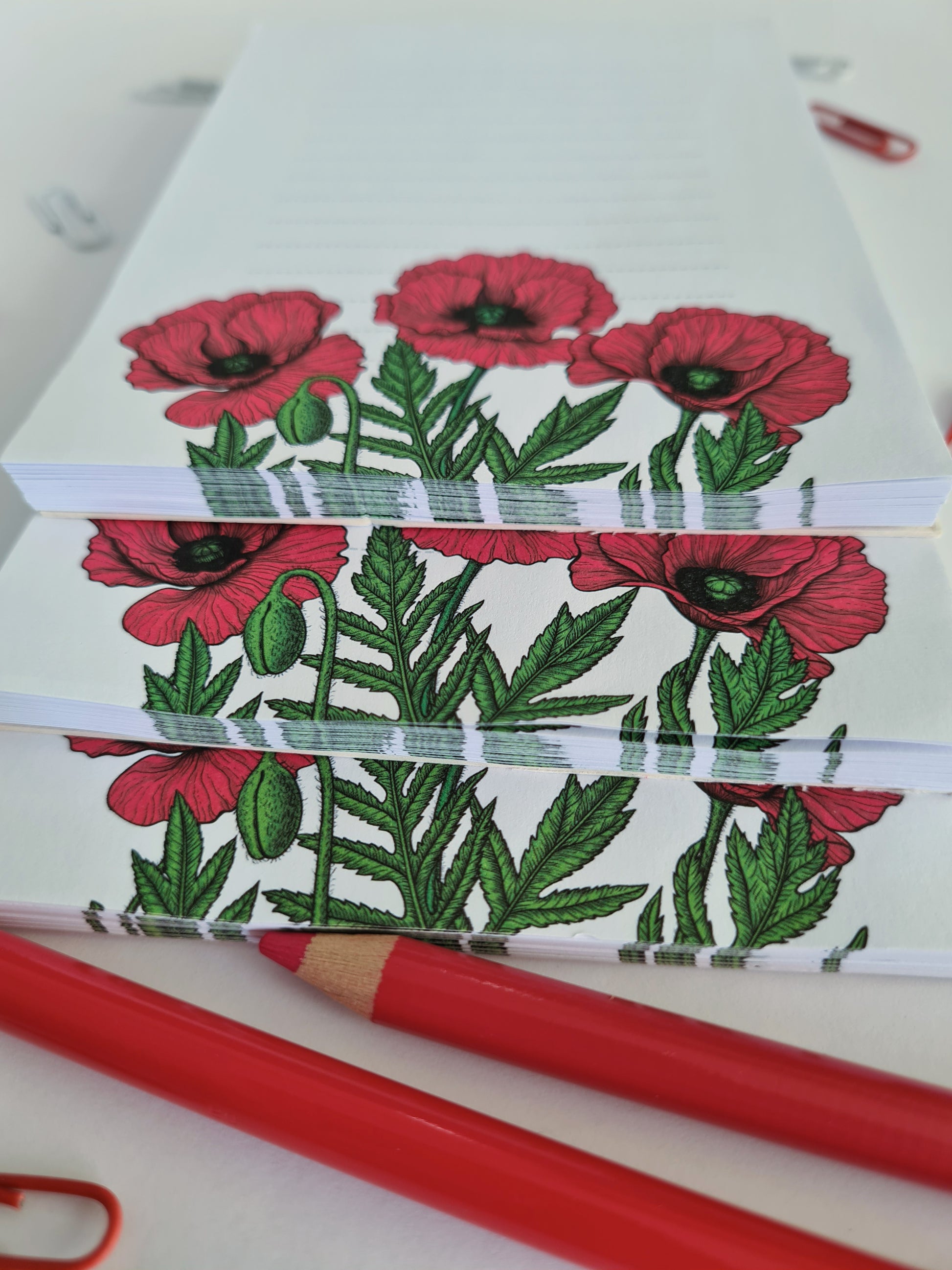 3 notepads ilustrated with red poppy flowers