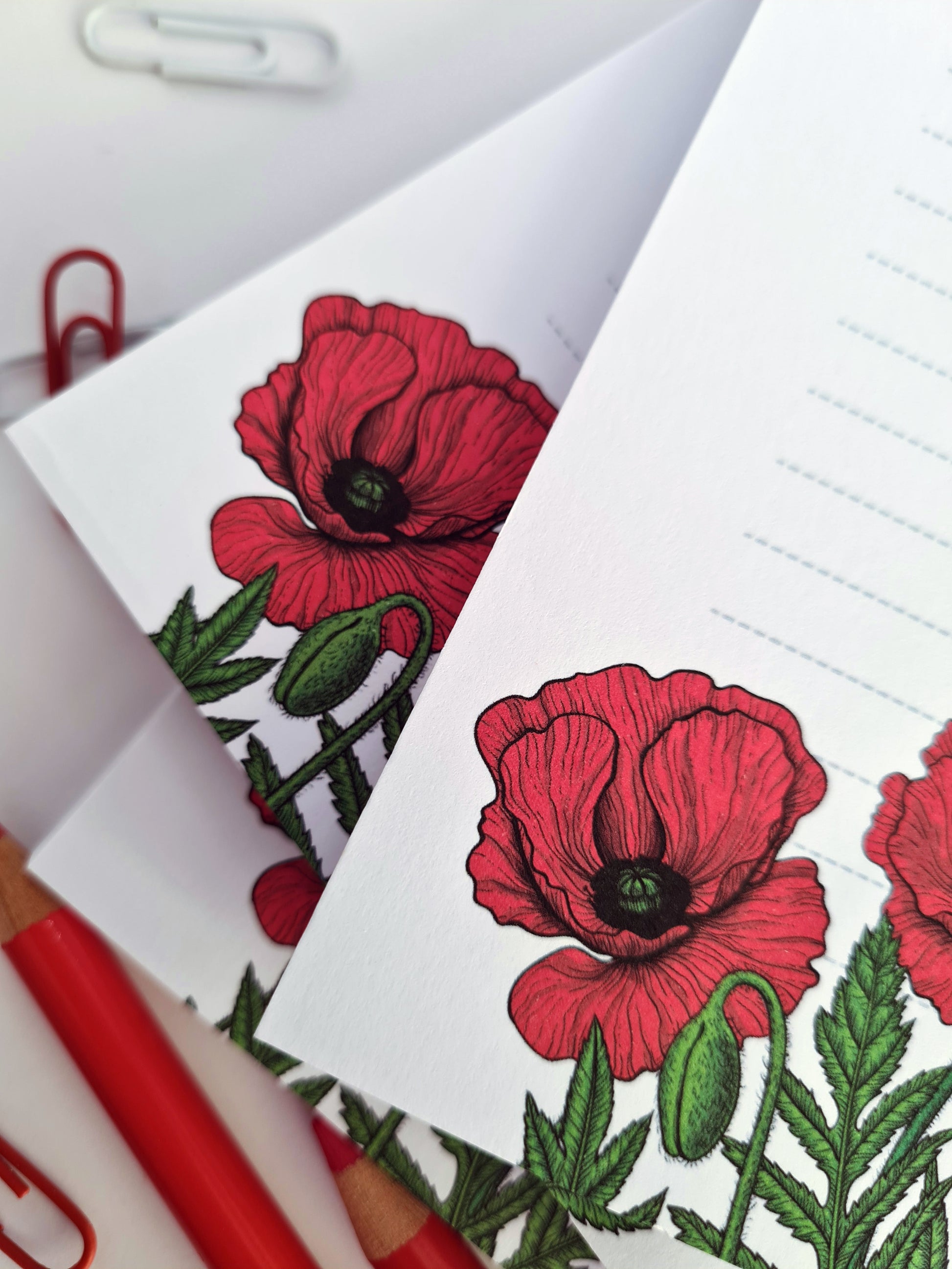 close up of notepad ilustrated with red poppy flowers