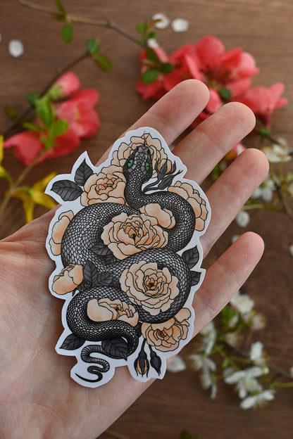 photo of a laminated paper sticker featuring illustration of a snake among rose flowers