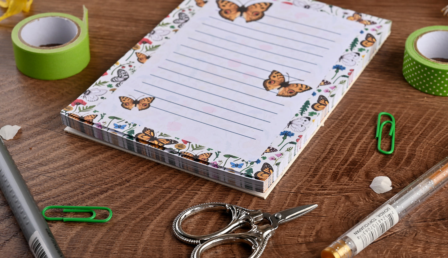 photo featuring a notepad illustrated with wildflowers and butterflies, corner close up