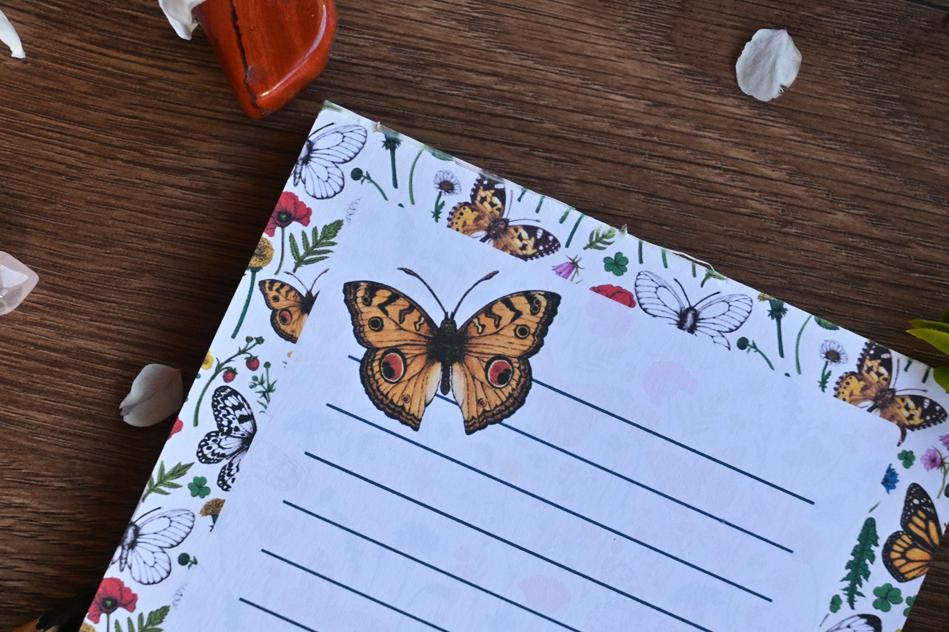 photo featuring a notepad illustrated with wildflowers and butterflies, corner close up