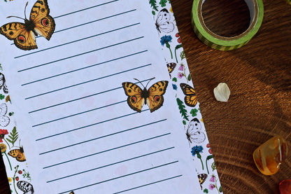 photo featuring a notepad illustrated with wildflowers and butterflies