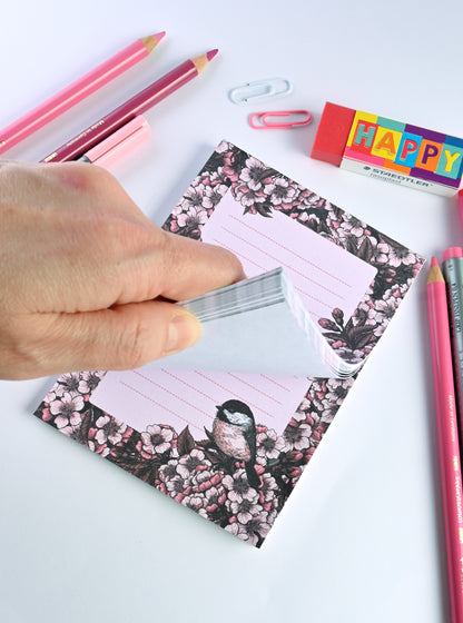 notepad featuring hand painted frame of cherry blosssom and chicakee bird in the lower right corner and  lined middle