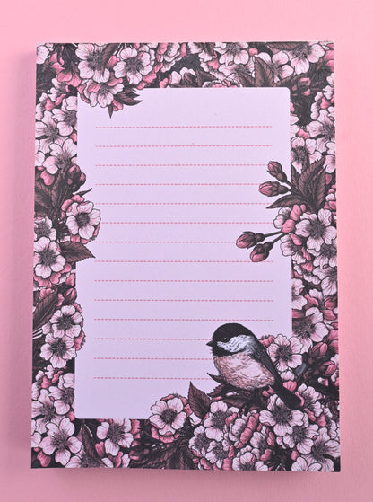 notepad featuring hand painted frame of cherry blosssom and chicakee bird in the lower right corner and  lined middle