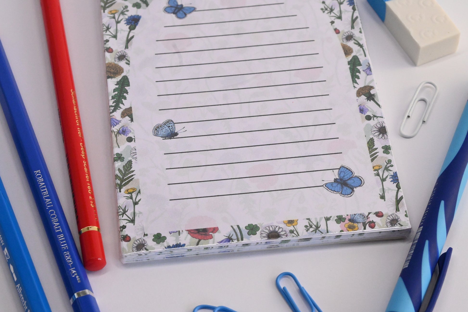 photo featuring a notepad illustrated with wildflowers and butterflies