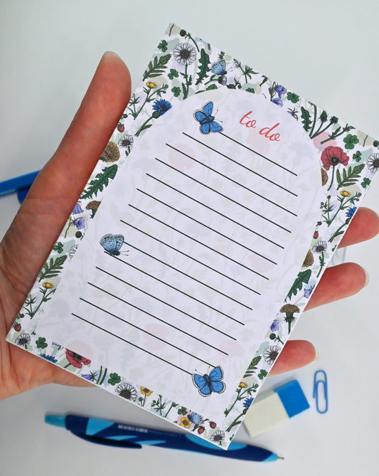 photo featuring a notepad illustrated with wildflowers and butterflies