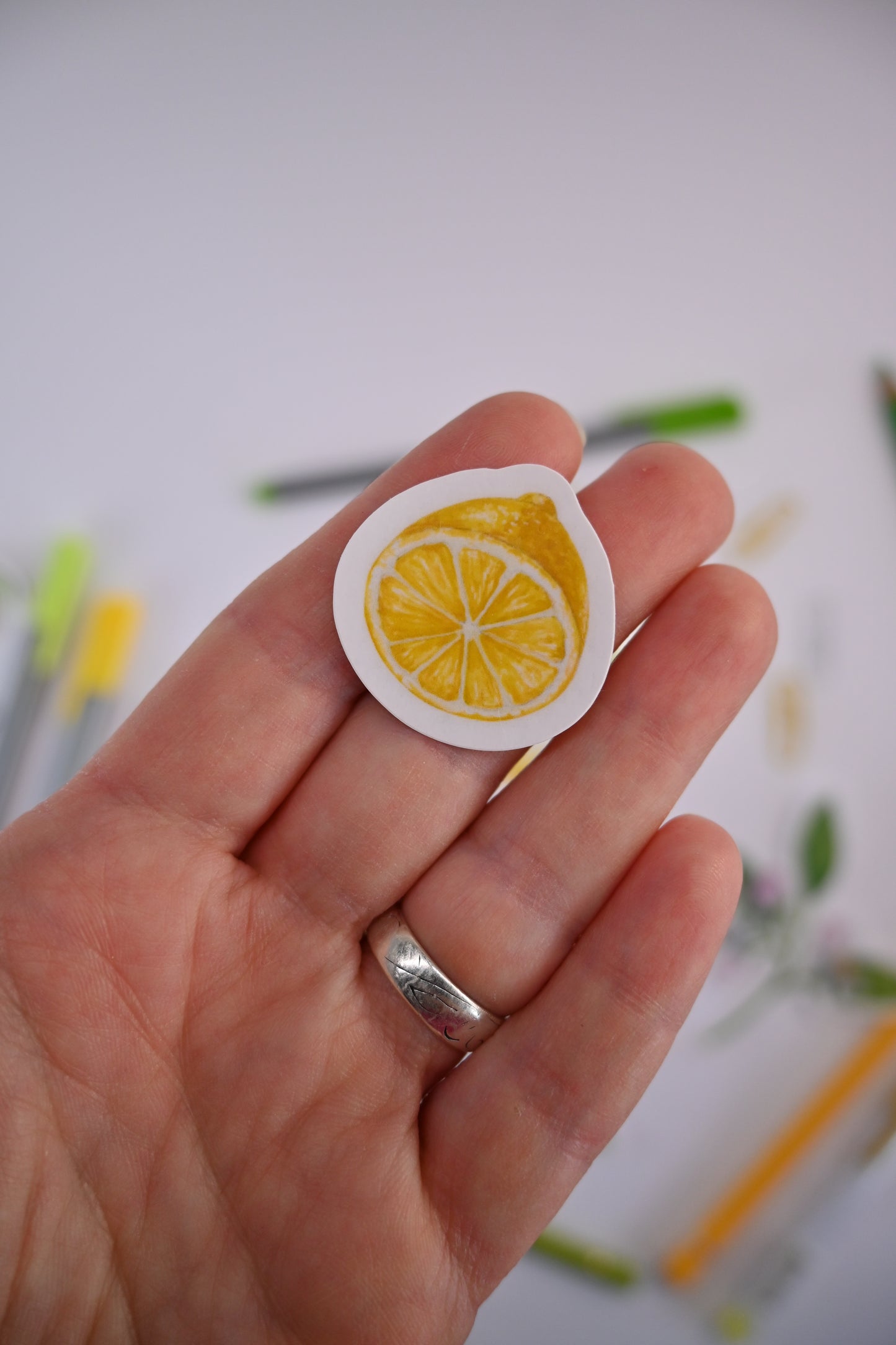 photo of a laminated sticker featuring a lemon slice painted with watercolors