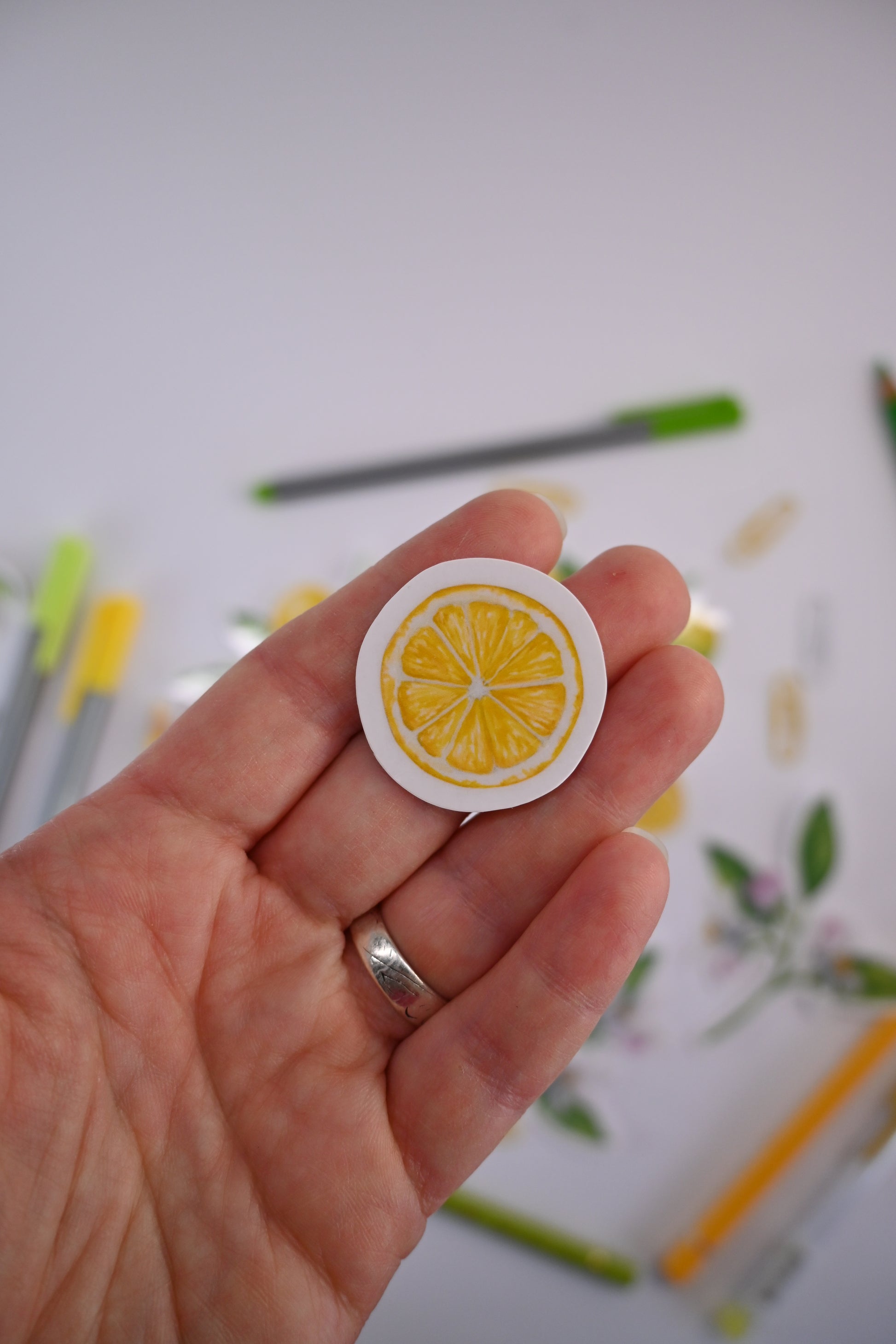 photo of a laminated sticker featuring a lemon slice painted with watercolors