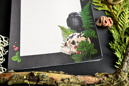 photo featuring a notepad illustrated with Raven and skull 