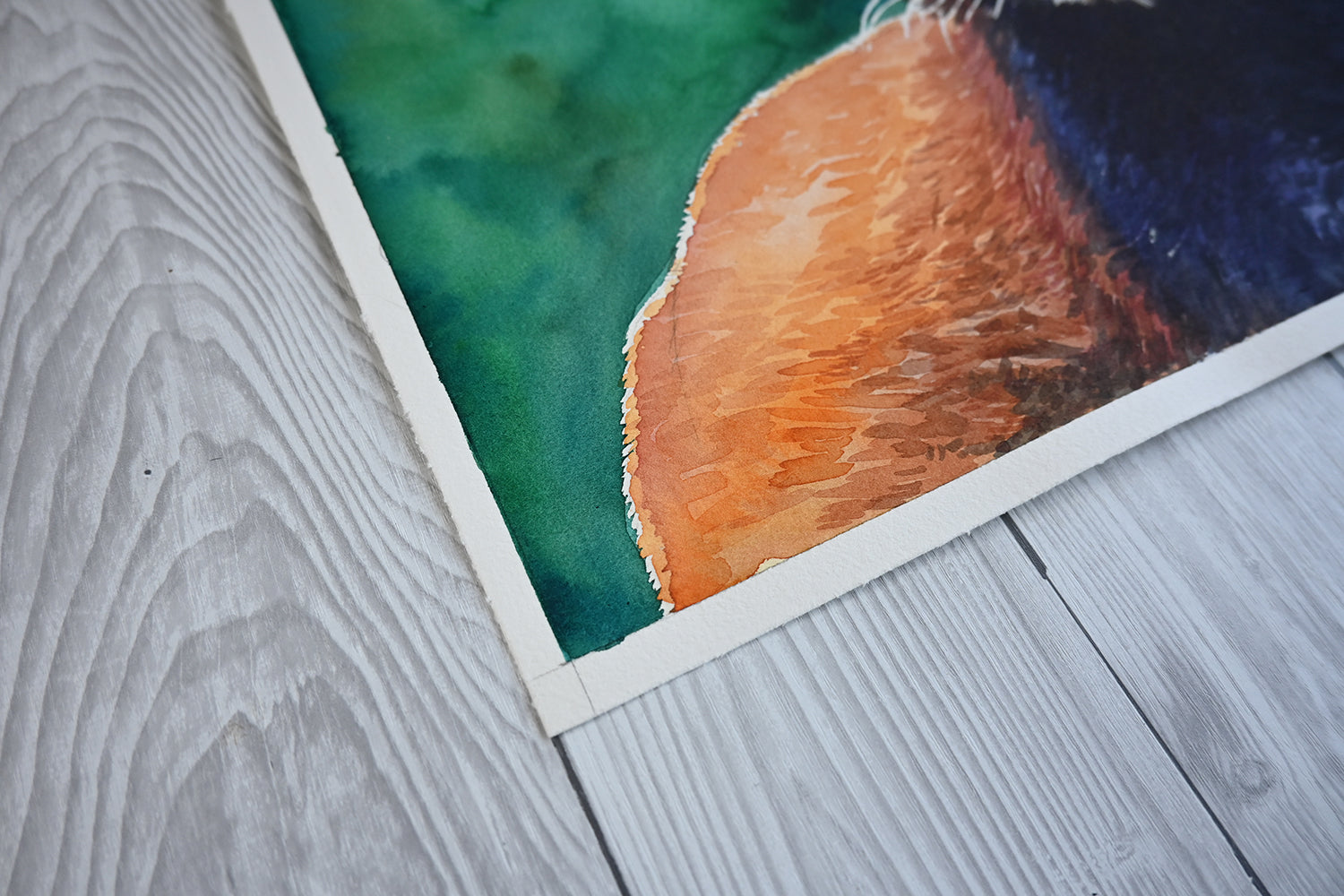 Close-up of a watercolor painting featuring red panda on a wooden surface