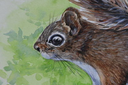 Close-up of a watercolor painting of a squirrel with a green leafy background