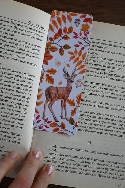 Book with a decorative bookmark featuring a deer and autumn leaves on an open book.