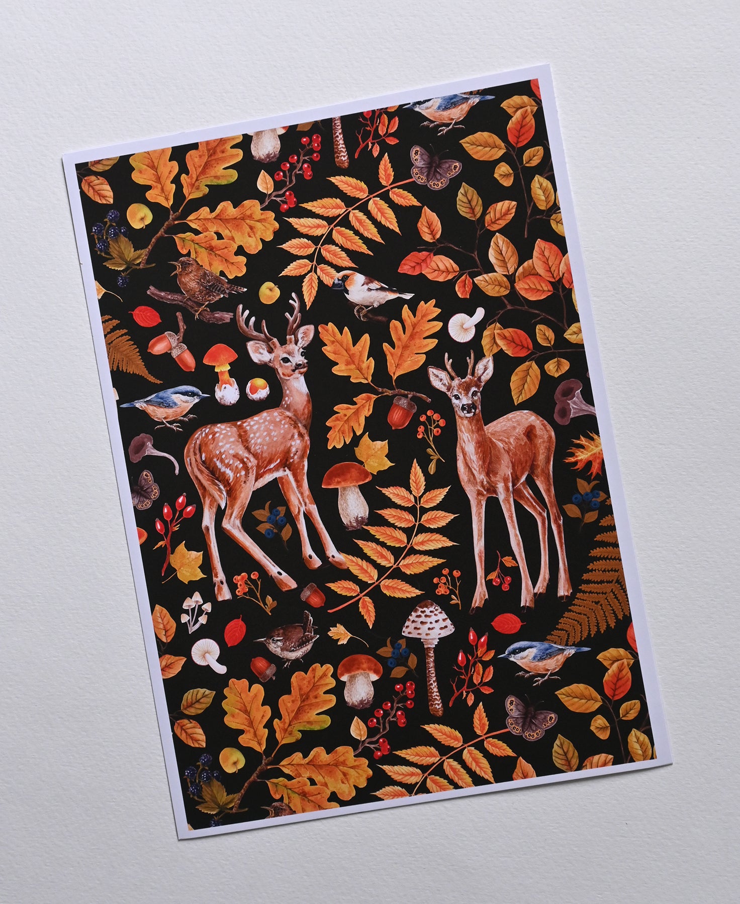 print of two deer among autumnal flora, mushrooms and birds on textured background