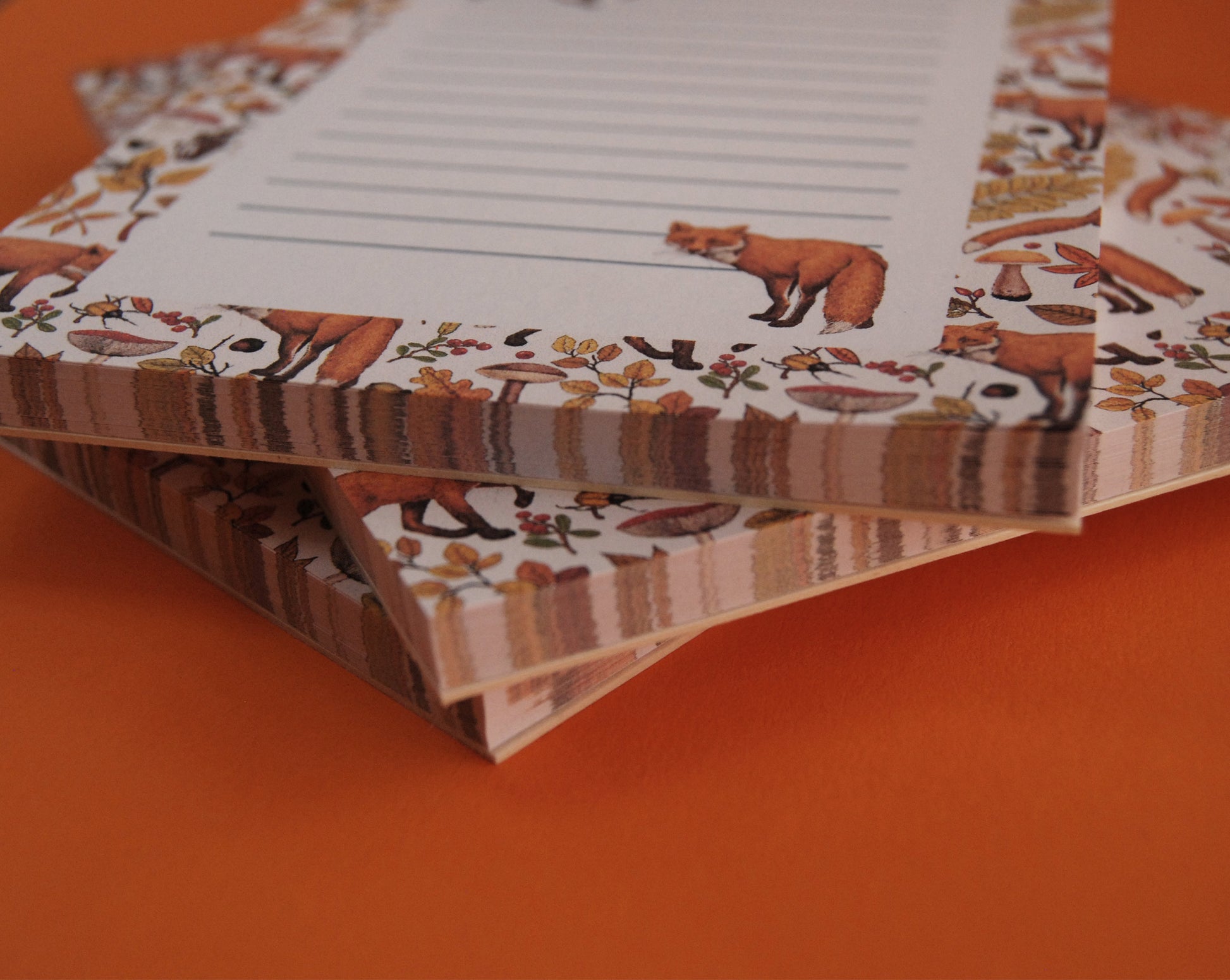 close up of notepads ilustrated with hand-painted red Foxes and autumn flora