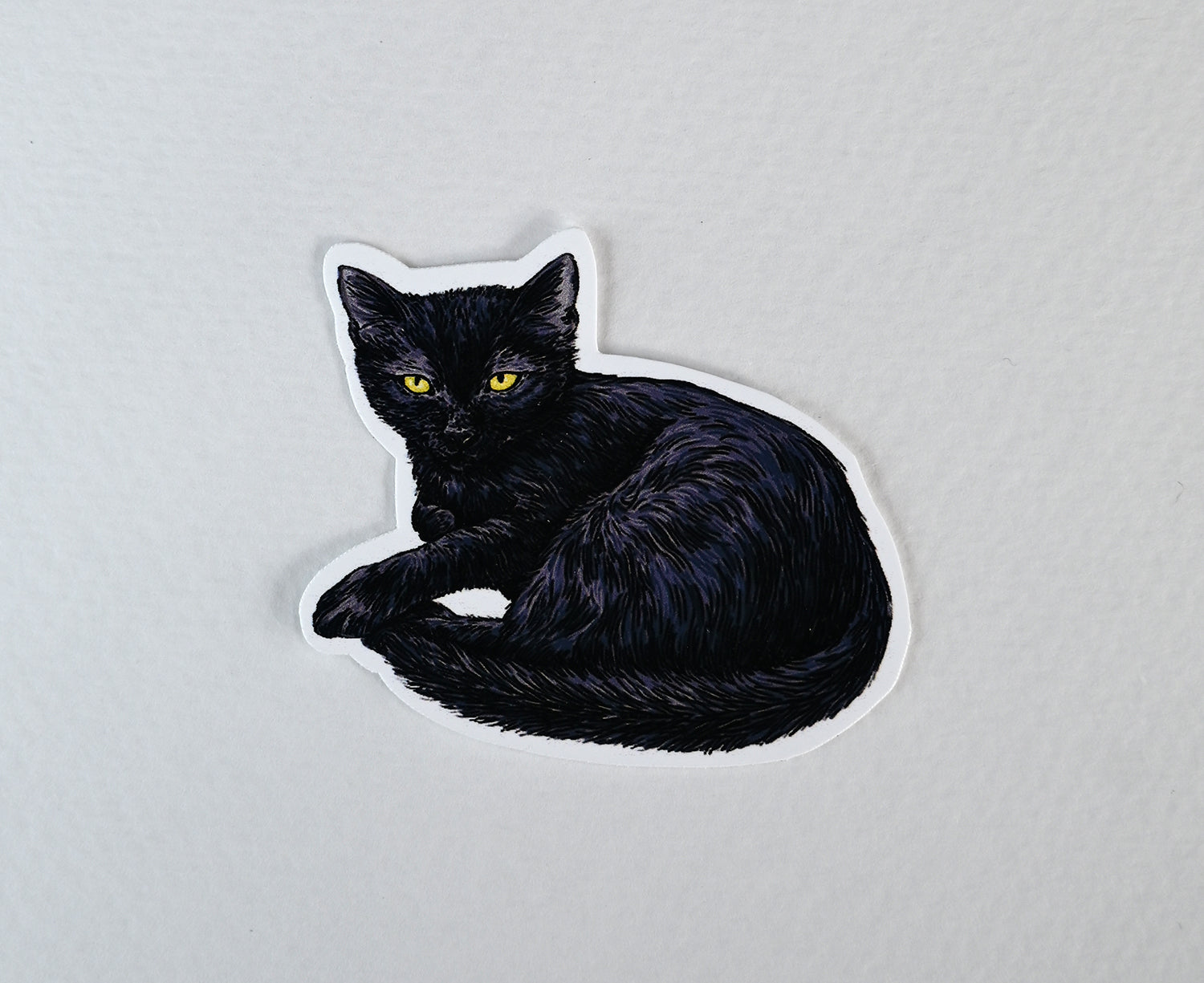 Black cat-shaped sticker on a white background