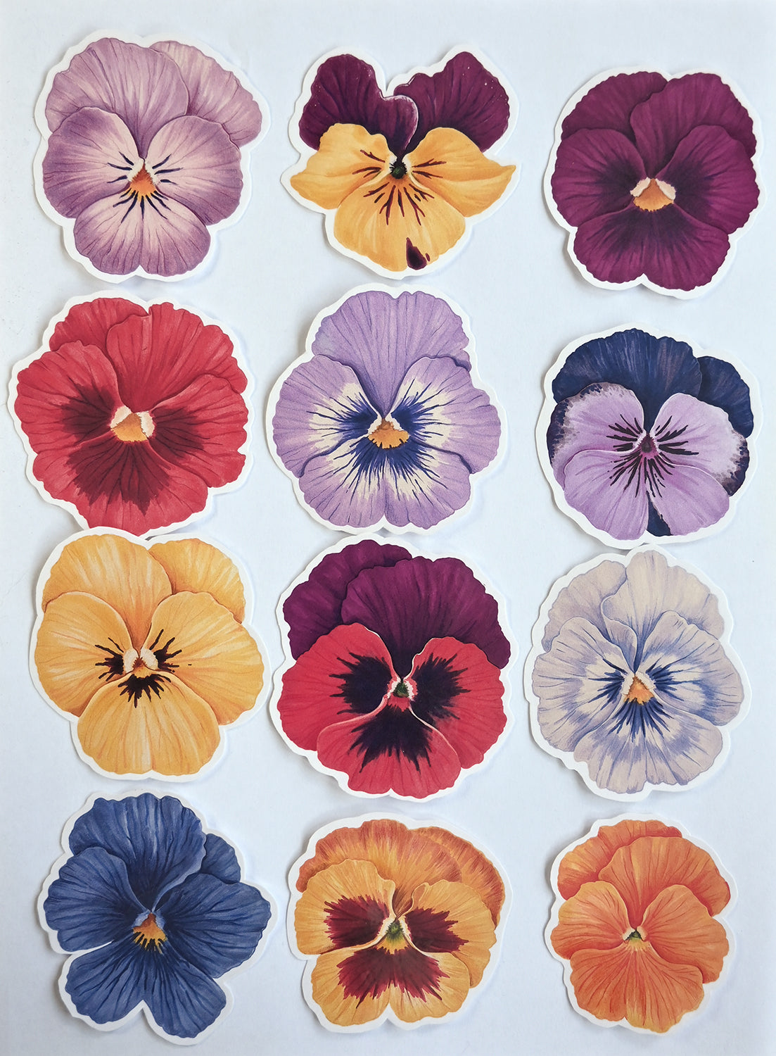 12 Colorful pansy flower stickers arranged in a grid on a light background