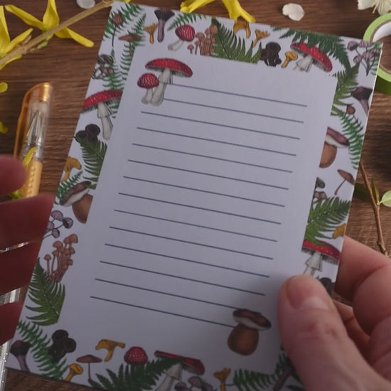 video featuring a notepad illustrated with wild mushrooms and fern