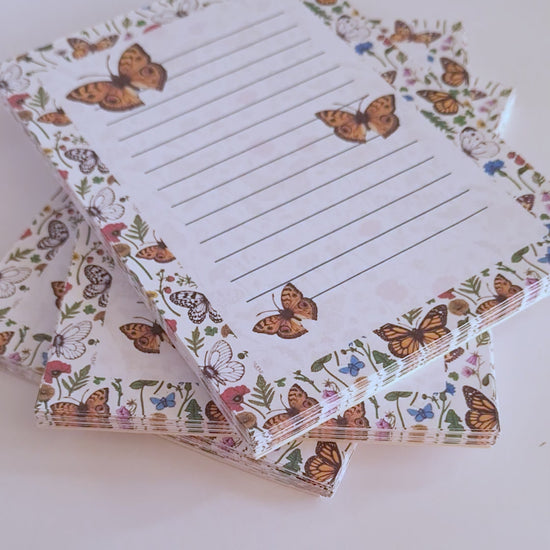 video featuring a notepad illustrated with wildflowers and butterflies