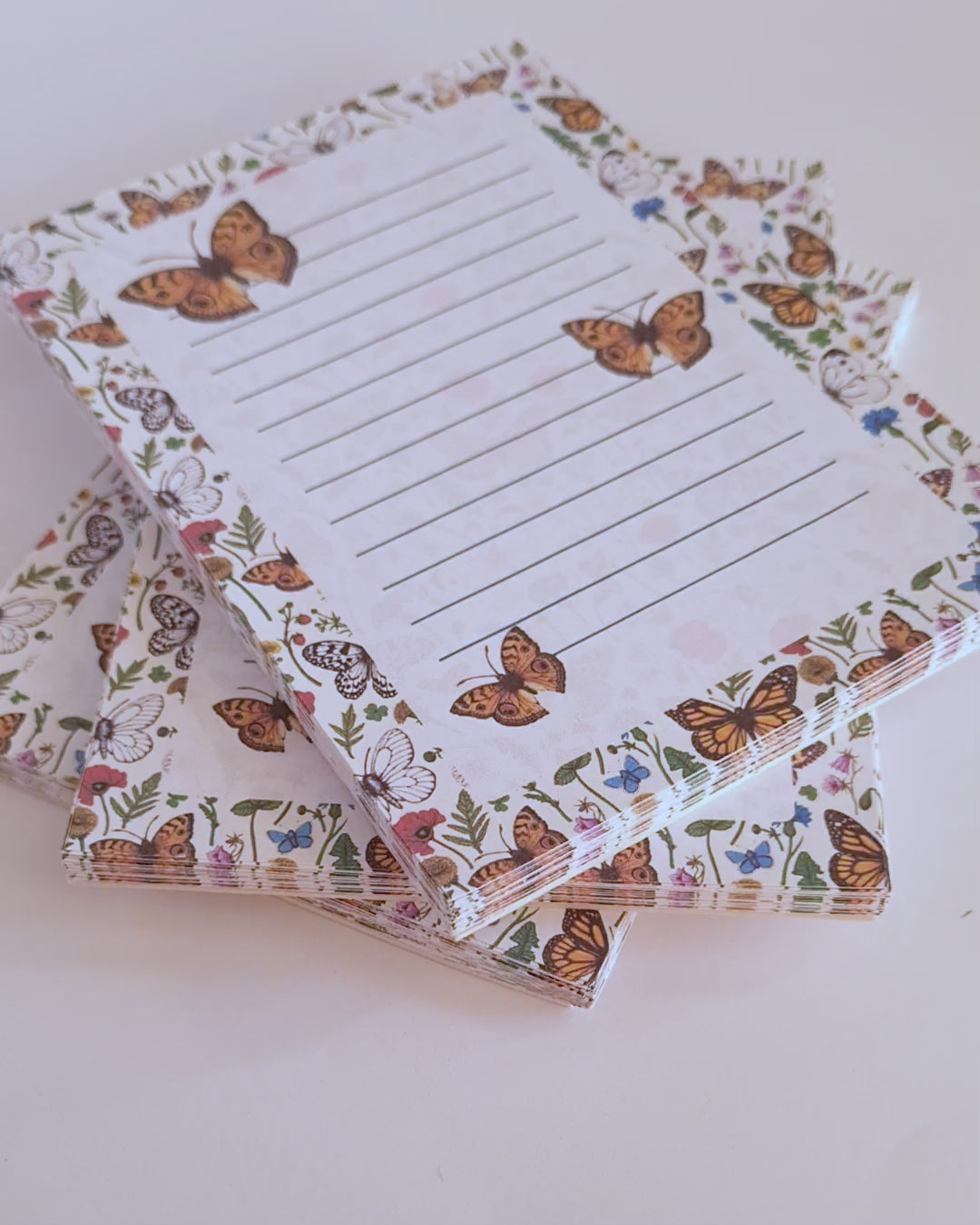 video featuring a notepad illustrated with wildflowers and butterflies