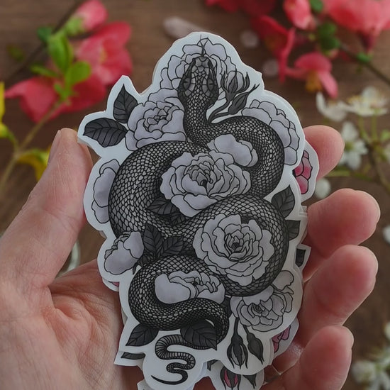 video showing of laminated paper stickers featuring illustration of a snake among rose flowers in 4 colorways