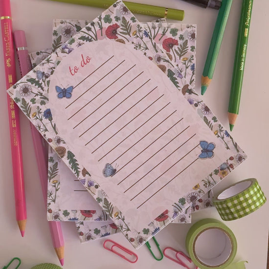 video featuring a notepad illustrated with wildflowers and butterflies