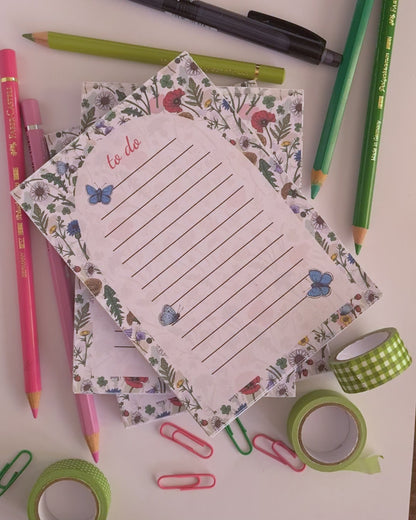 video featuring a notepad illustrated with wildflowers and butterflies