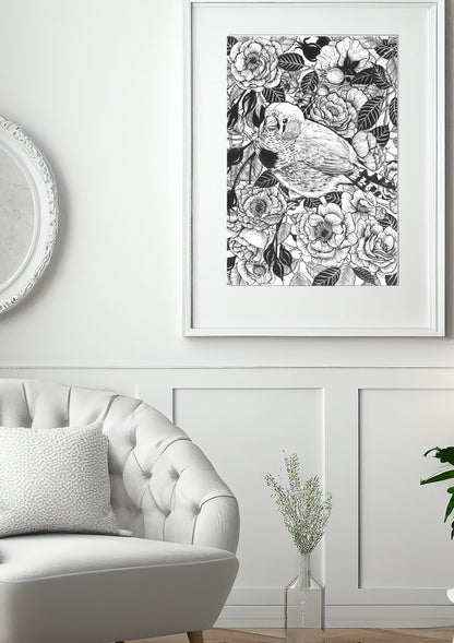Framed ink painting in black and white roses and bird illustration above a white sofa.